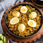 Spiced rice topped with boiled egg halves and cilantro