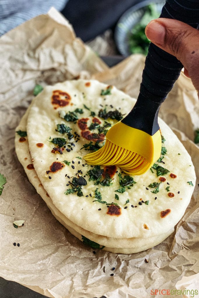 brushing butter on Indian flatbread
