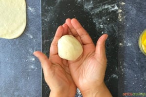 two hands holding ball of dough