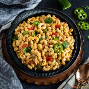 A bowl full of mac and cheese with Indian spices and vegetables