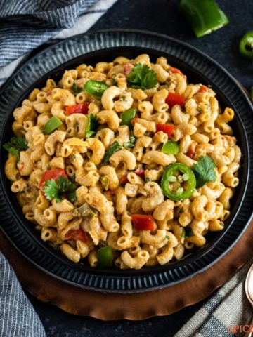 A bowl full of mac and cheese with Indian spices and vegetables