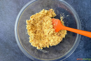 Wet semolina mix in a bowl with orange spatula