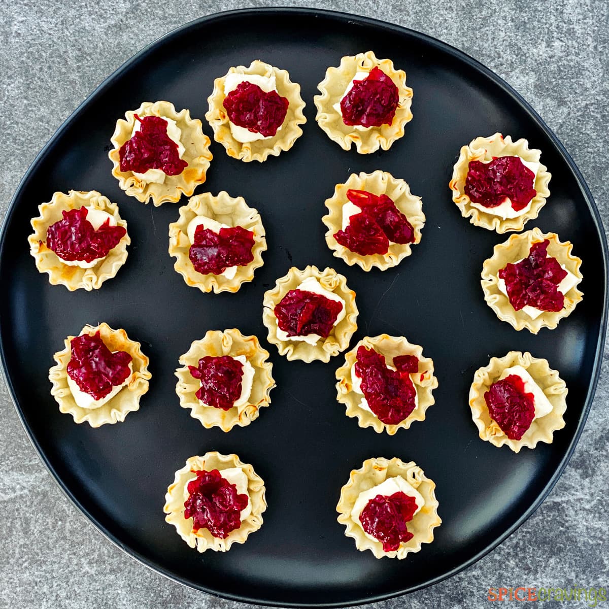 Uncooked phyllo cups with brie and cranberry sauce inside