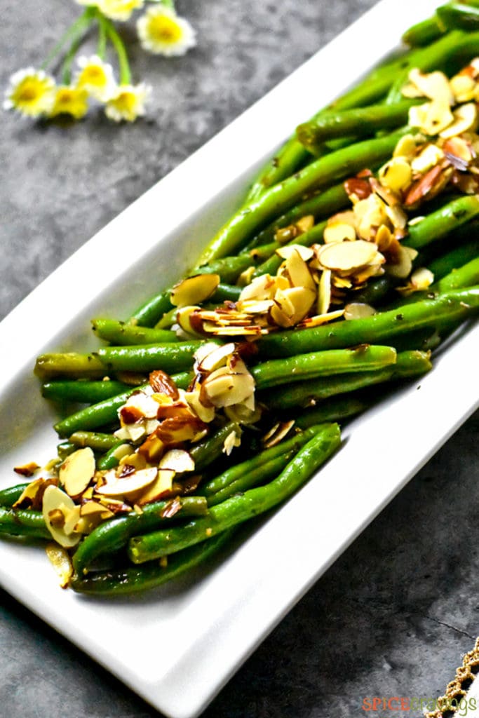 Green beans with almonds served on a white plate
