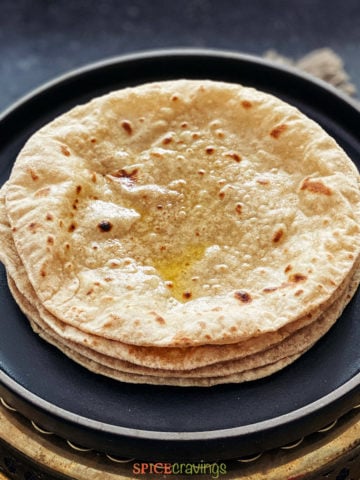 Close up shot of a stack of rotis smeared with ghee