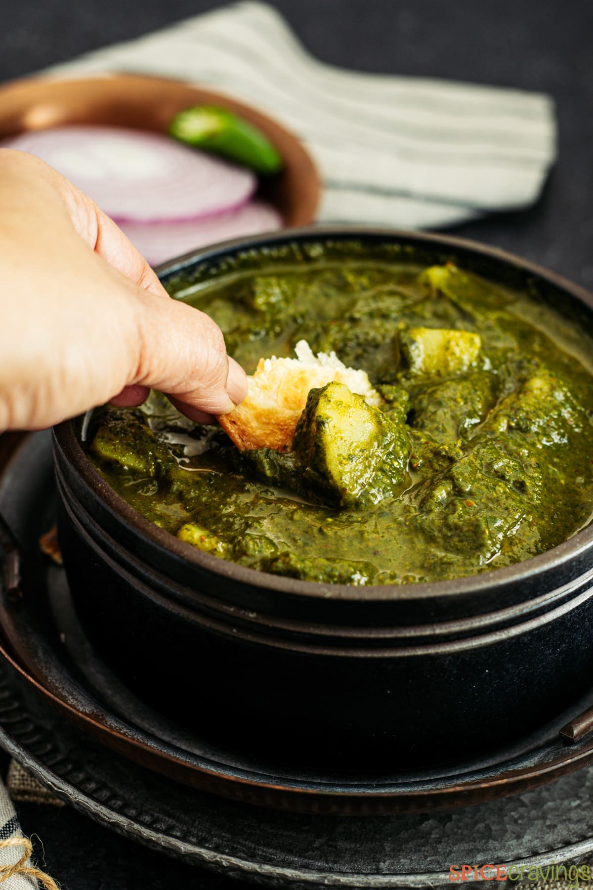 Scooping Saag Aloo with Naan