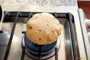 Puffing rotis on the stove over direct flame