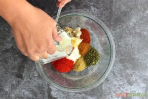 Mixing spices and yogurt in a bowl
