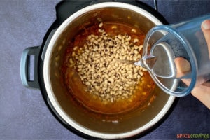 Pouring water in instant pot with lobia beans