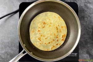 Paratha cooking inside a frying pan