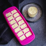 Pink ice cube tray and small jar filled with ground ginger and garlic