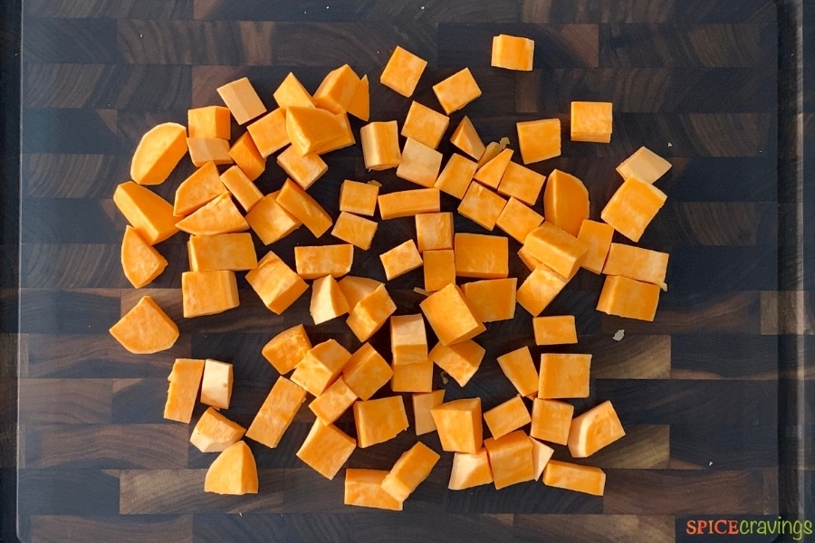 Cubes of raw sweet potatoes on a cutting board