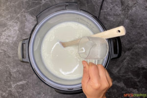 Pouring vinegar in milk in a pressure cooker