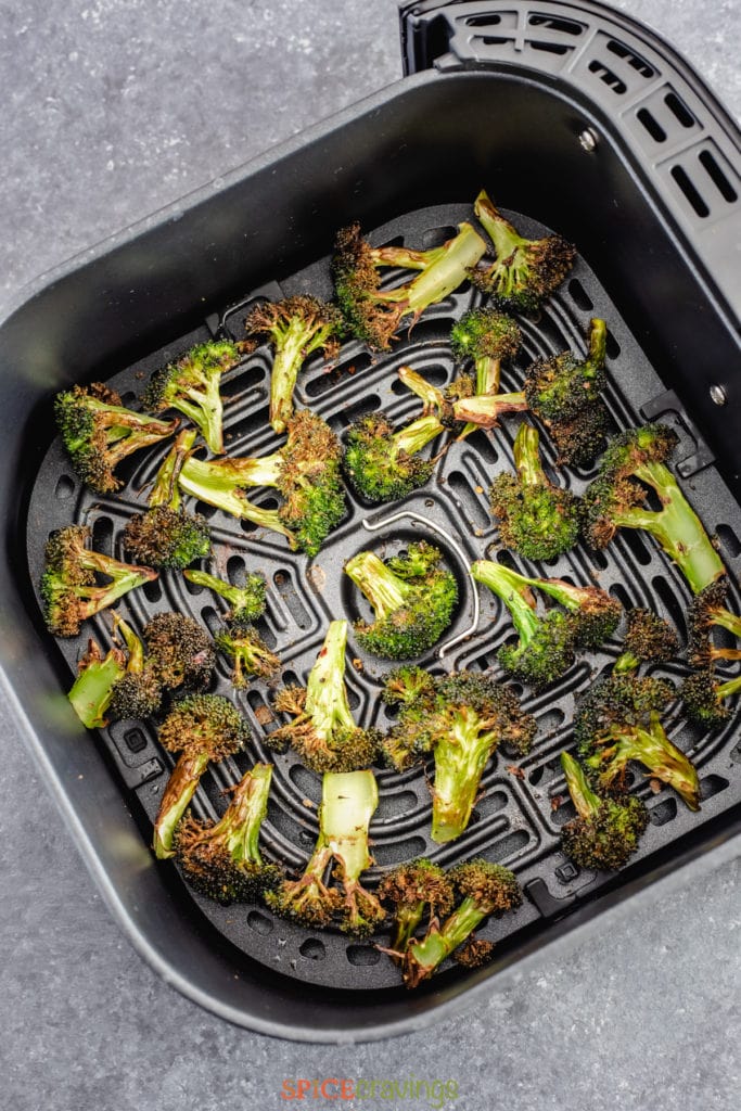 Roasted broccoli florets in the air fryer basket