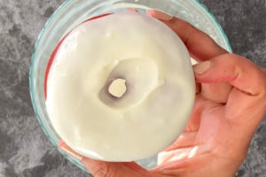 Dipping donuts into cream cheese icing