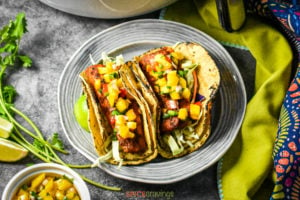 Fish tacos topped with mango salsa