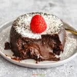 Chocolate lava cake with a melty core topped with raspberry