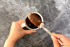 Adding ingredients to a mug to make Nutella Almond Flour Mug Cake