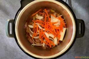 Sliced carrots, onion over chicken in instant pot