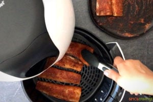 Placing seasoned fish fillets in the air fryer