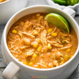 A white mug filled with white chicken chili