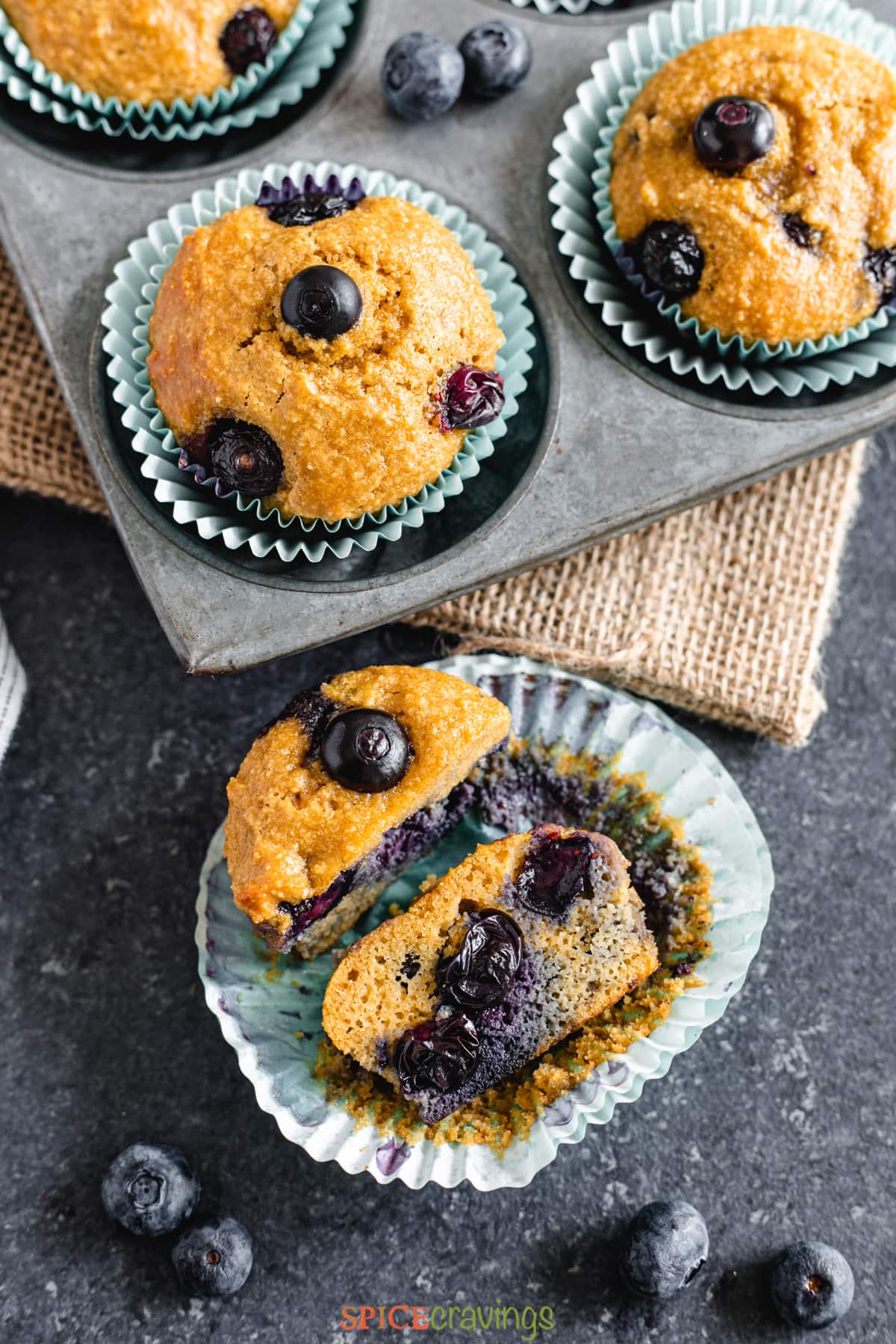 Blueberry Muffin split in half next to tray of almond flour muffins
