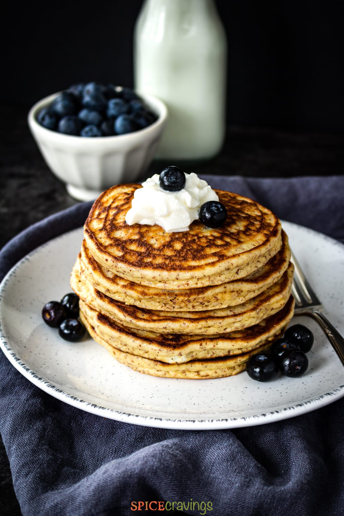 Almond flour pancakes topped with whipped cream and blueberries