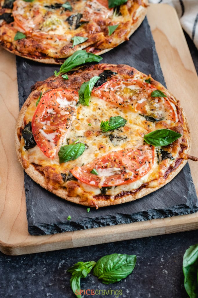 Cooked pizza topped with fresh basil
