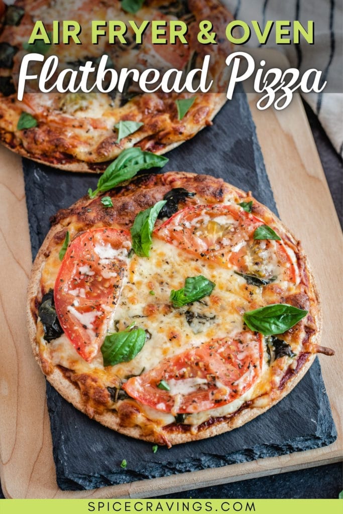 Cooked pizza with tomato and basil on a slate block