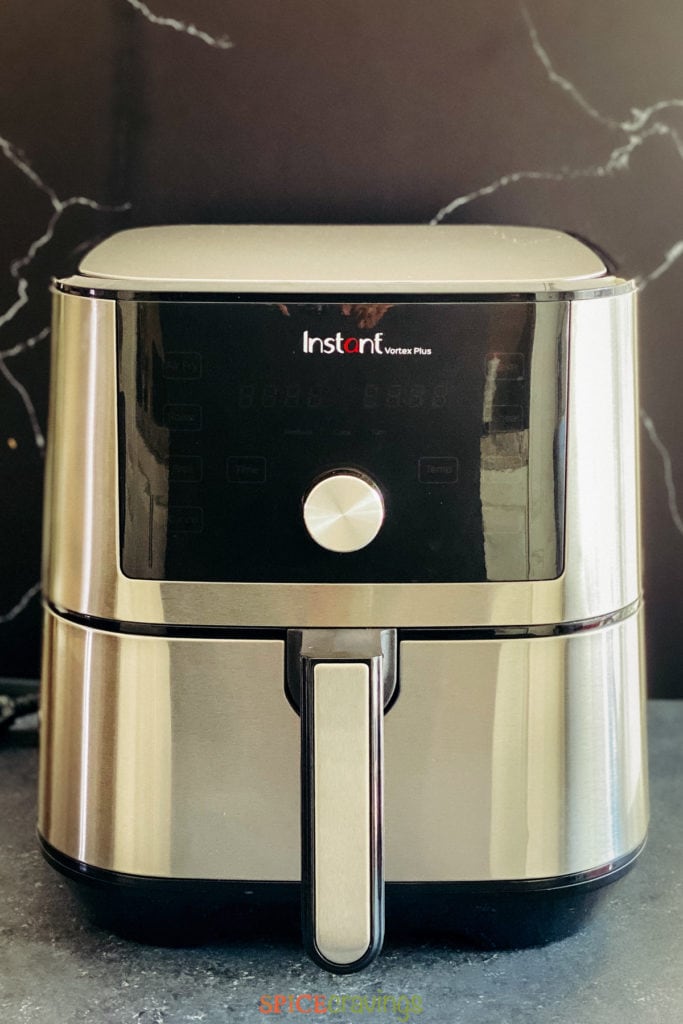 Air fryer on counter against black background