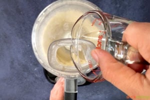 pouring water into oil and flour mixture in food processor