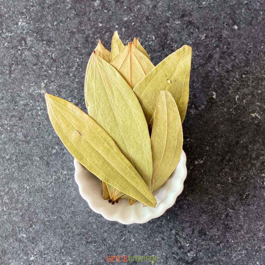 dried bay leaves in white bowl