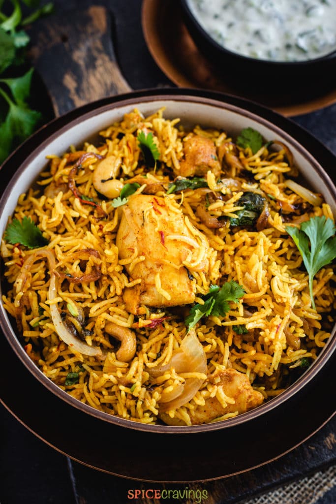 Close up of Chicken biryani topped with cilantro and saffron