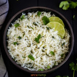 Bowl of cilantro lime rice with 2 lime slices