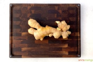 fresh ginger root on wood cutting board