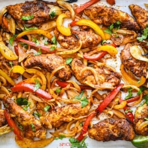 Mexican spiced chicken, peppers and onion on baking sheet