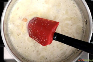 Stiring milk and water in sauce pan with semolina