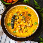 Indian yellow lentils called dal tadka garnished with oil and cilantro