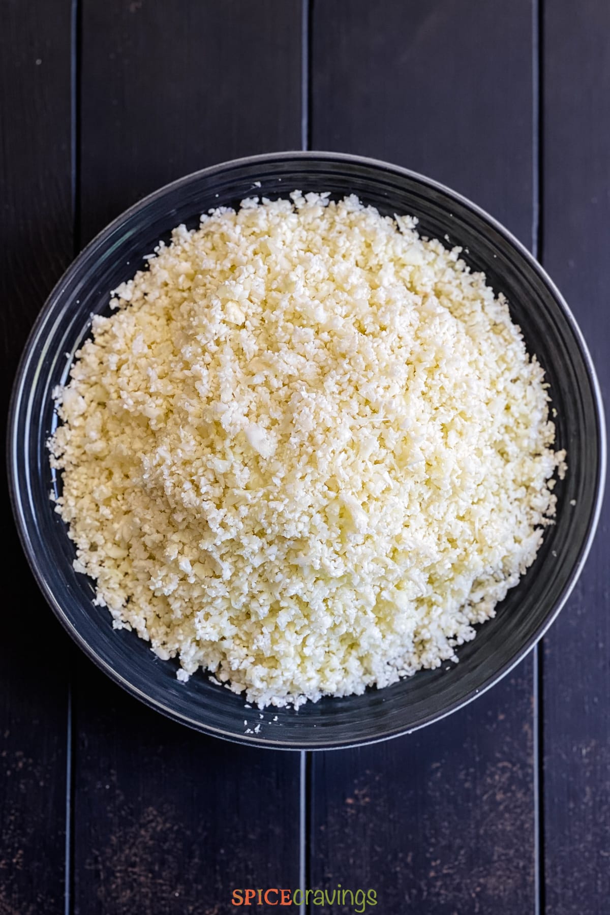 Bowl of cauliflower rice on wooden table