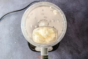 Cauliflower florets in feeder tube of food processor