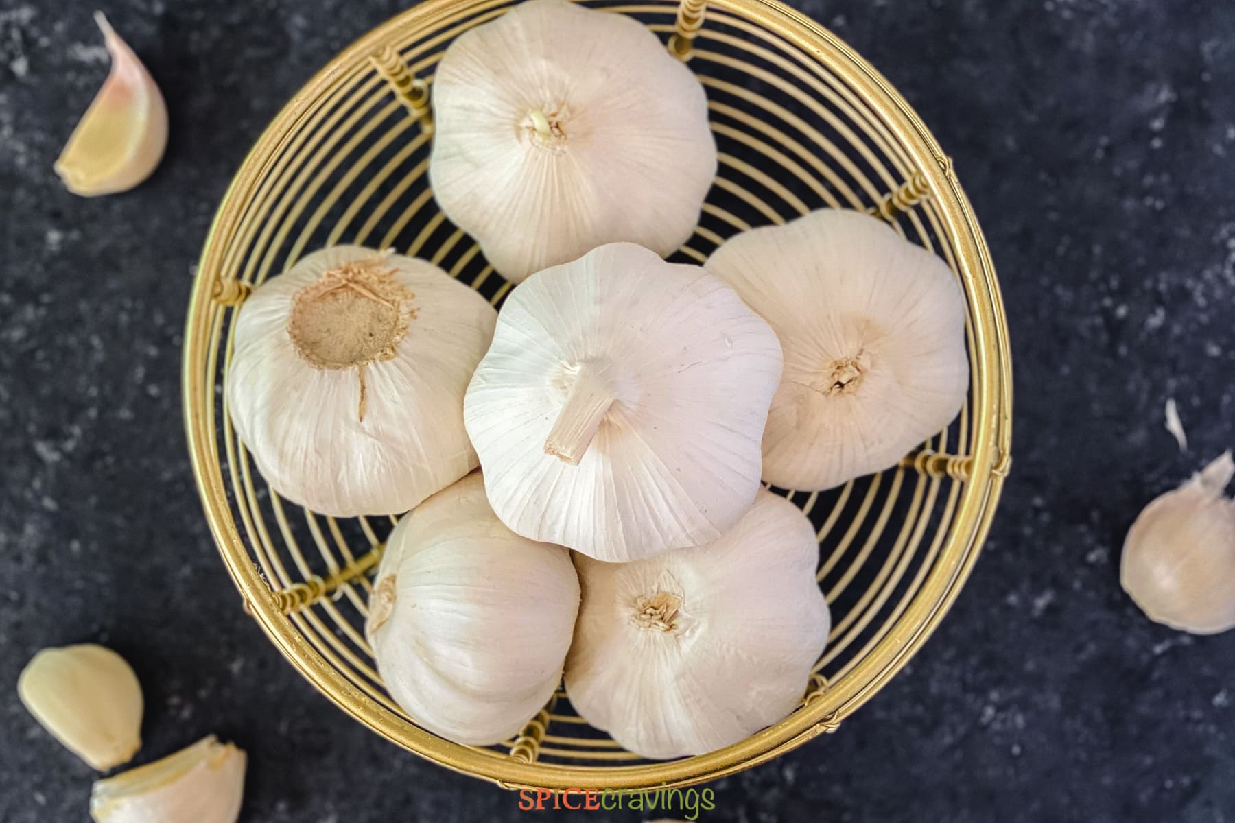 six garlic heads in wooden bowl