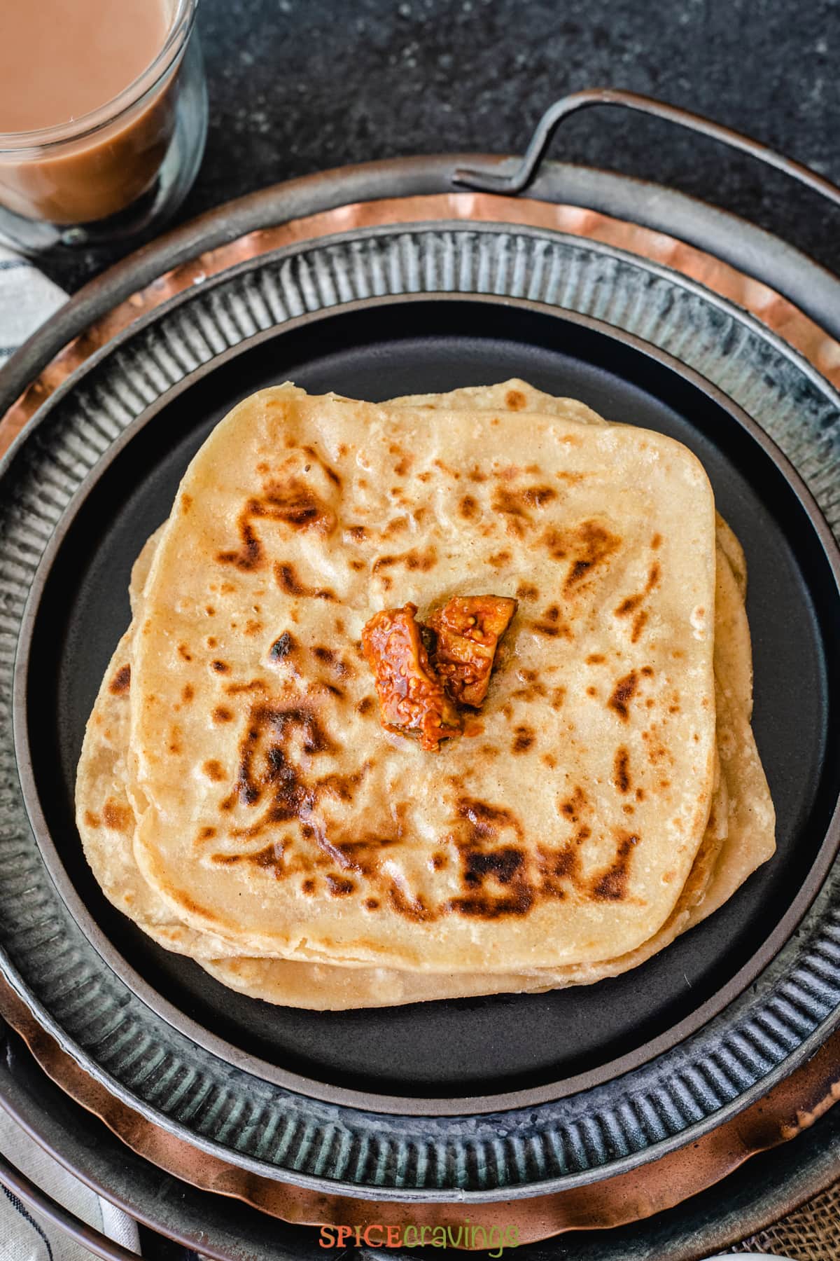 Stack of paratha topped with Indian pickle