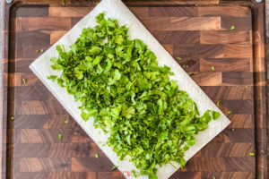 chopped cilantro spread out on paper towel
