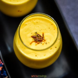 Sweet Mango lassi in glass garnished with saffron strands