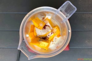 Mango chunks, yogurt, saffron and cardamom in blender jar