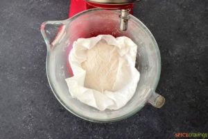 Covering dough with damp towel in stand mixer bowl