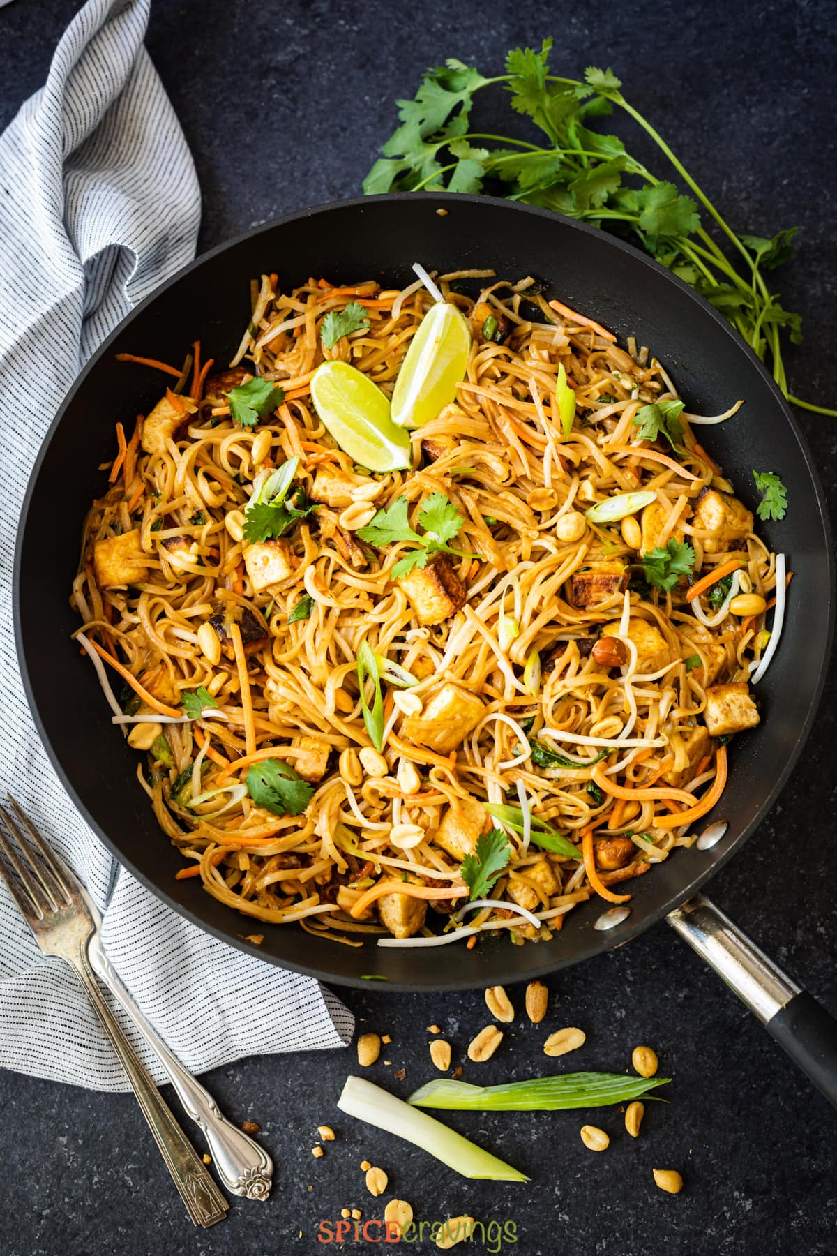 vegan pad thai recipe in wok with lime wedges