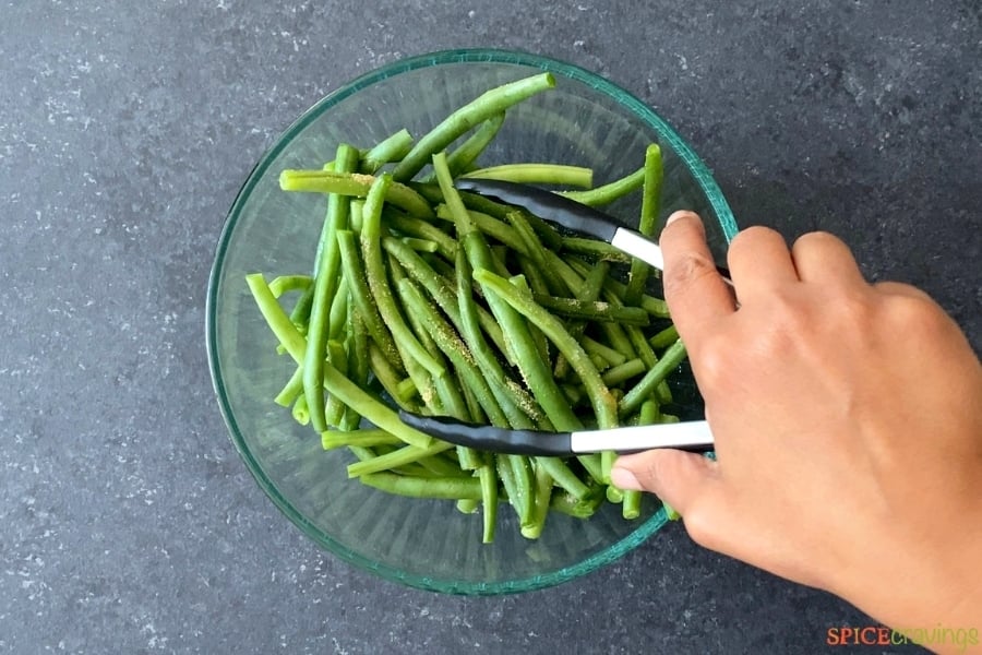 seasoned green beans being mixed