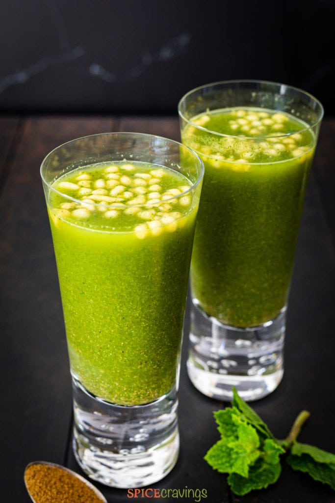 Two glasses of cilantro-mint and cumin flavored lemonade topped with crunchy boondi