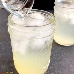 Pouring water to mason jar to make lemonade